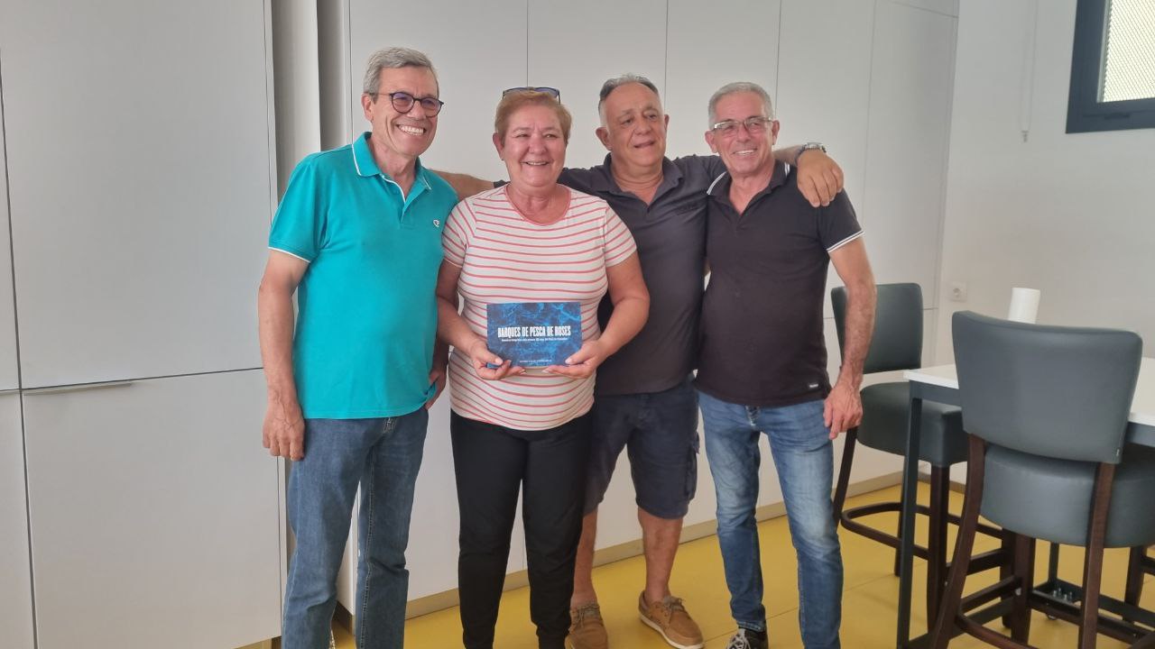 Recogiendo el libro que recoge todas las embarcaciones que han pasado por la cofradía en los últimos 100 años.